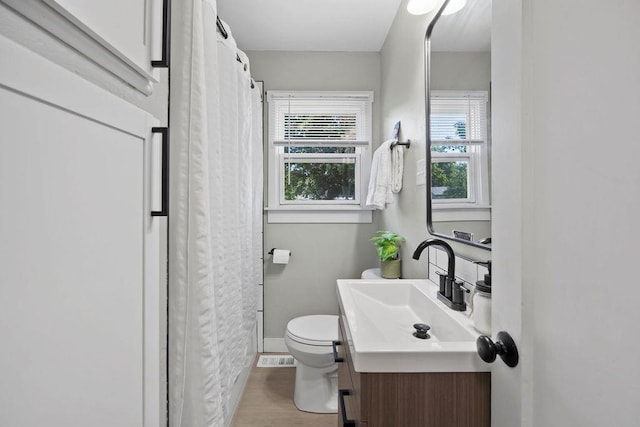 811 E Dalke Ave, Spokane, WA 99208 - bathroom featuring toilet, vanity, wood finished floors, baseboards, and a shower with curtain
