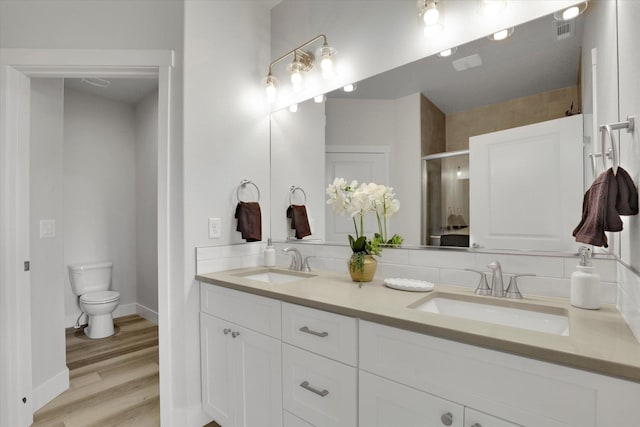 1109 N Country Club Dr Unit 20, Deer Park, WA 99006 - bathroom with double vanity, a shower stall, toilet, wood finished floors, and baseboards