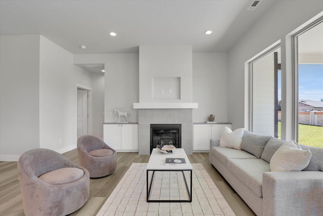 1109 N Country Club Dr Unit 20, Deer Park, WA 99006 - living area featuring light wood-type flooring, a tiled fireplace, recessed lighting, and baseboards