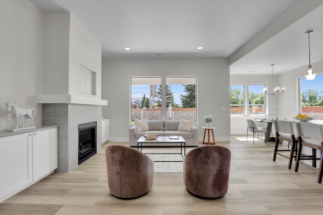 1109 N Country Club Dr Unit 20, Deer Park, WA 99006 - living room with light wood-type flooring, a tile fireplace, a chandelier, recessed lighting, and baseboards