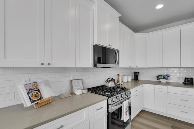 1109 N Country Club Dr Unit 20, Deer Park, WA 99006 - kitchen featuring stainless steel appliances, white cabinets, decorative backsplash, light wood finished floors, and recessed lighting