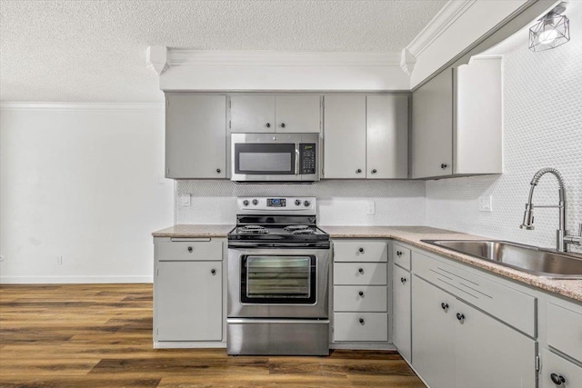 917 E Indiana Ave, Spokane, WA 99207 - kitchen with stainless steel appliances, a sink, crown molding, a textured ceiling, and backsplash