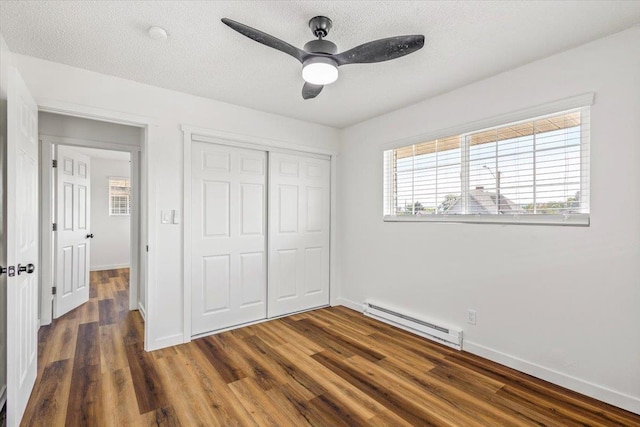 917 E Indiana Ave, Spokane, WA 99207 - unfurnished bedroom featuring a baseboard radiator, a closet, baseboards, and a textured ceiling