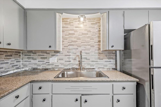 917 E Indiana Ave, Spokane, WA 99207 - kitchen with a sink, freestanding refrigerator, backsplash, and light countertops