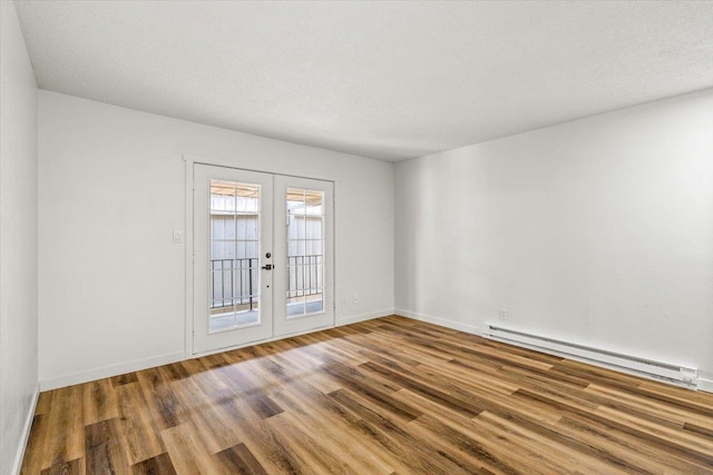 917 E Indiana Ave, Spokane, WA 99207 - empty room featuring baseboard heating, french doors, wood finished floors, and baseboards