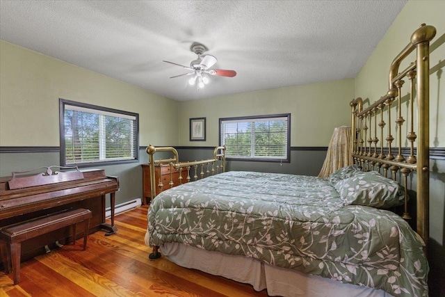 3720 E Bridges Rd, Elk, WA 99009 - bedroom with a baseboard heating unit, wood finished floors, a textured ceiling, and ceiling fan