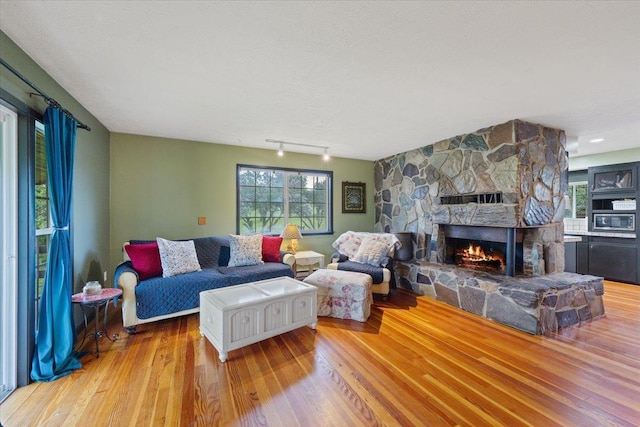 3720 E Bridges Rd, Elk, WA 99009 - living room with wood finished floors, a stone fireplace, and track lighting