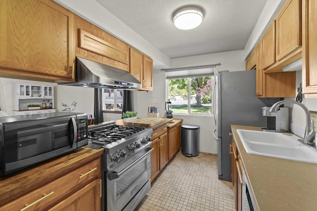 112 E Weile Ave Unit # 1, Spokane, WA 99208 - kitchen featuring ventilation hood, high end stove, black microwave, a sink, and brown cabinets