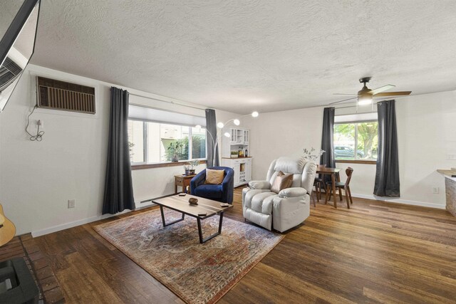 112 E Weile Ave Unit # 1, Spokane, WA 99208 - living room with wood finished floors, a textured ceiling, a ceiling fan, an AC wall unit, and baseboards