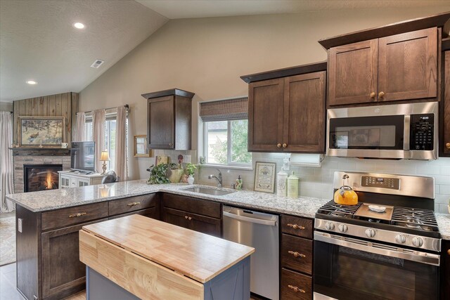 8202 W Quaking Rd, Spokane, WA 99224 - kitchen featuring appliances with stainless steel finishes, a sink, a peninsula, butcher block counters, and decorative backsplash