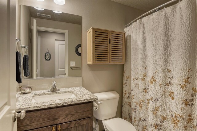 8202 W Quaking Rd, Spokane, WA 99224 - full bathroom featuring vanity, backsplash, toilet, and a shower with shower curtain