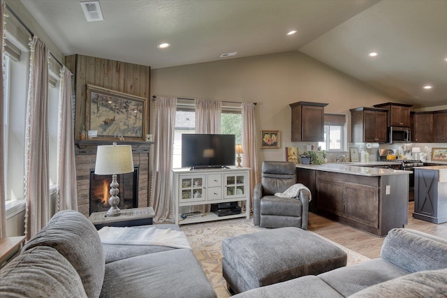 8202 W Quaking Rd, Spokane, WA 99224 - living area with a large fireplace, recessed lighting, high vaulted ceiling, and light wood-type flooring