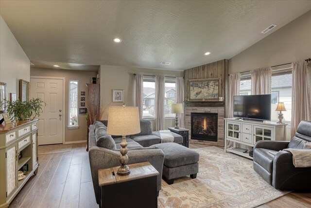 8202 W Quaking Rd, Spokane, WA 99224 - living room with healthy amount of natural light, a large fireplace, recessed lighting, wood finished floors, and vaulted ceiling