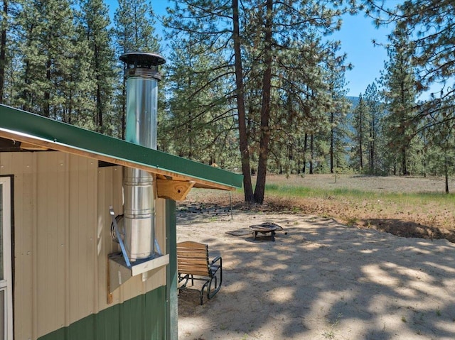 5 Crestview Rd, Kettle Falls, WA 99141 - view of patio with a fire pit and a wooded view