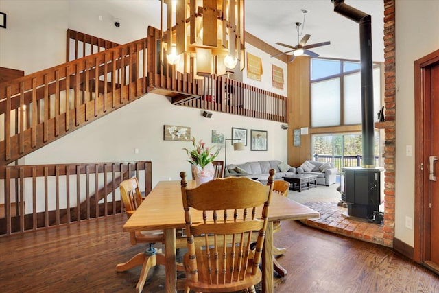 13625 S Sherman Rd, Spokane, WA 99224 - dining area featuring a high ceiling, ceiling fan, a wood stove, wood finished floors, and stairs
