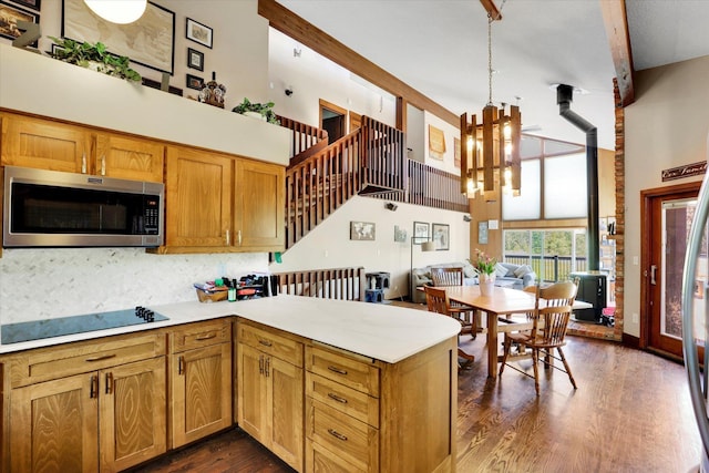 13625 S Sherman Rd, Spokane, WA 99224 - kitchen with stainless steel microwave, a towering ceiling, a chandelier, a peninsula, and light countertops