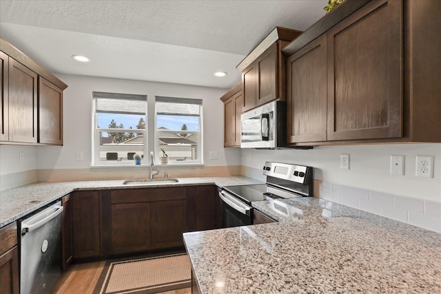 8620 W 8th Ave, Spokane, WA 99224 - kitchen with stainless steel appliances, a sink, light stone countertops, recessed lighting, and a textured ceiling