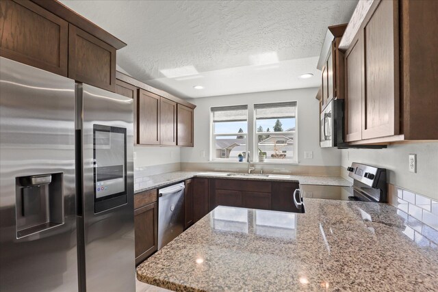 8620 W 8th Ave, Spokane, WA 99224 - kitchen featuring appliances with stainless steel finishes, a sink, a textured ceiling, light stone countertops, and recessed lighting