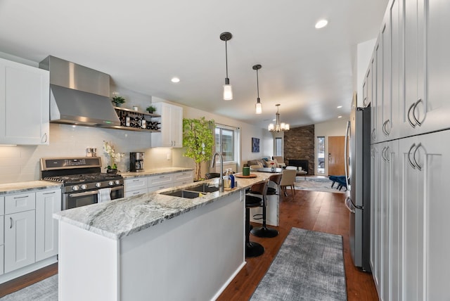2518 W Bridge Ave, Spokane, WA 99201 - kitchen with appliances with stainless steel finishes, a sink, wall chimney range hood, white cabinets, and recessed lighting