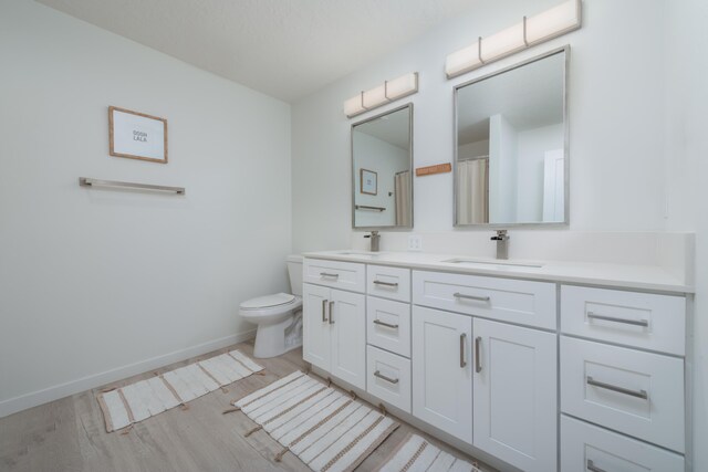 5125 N Ellie Ln, Spokane, WA 99217 - bathroom with double vanity, wood finished floors, baseboards, and toilet