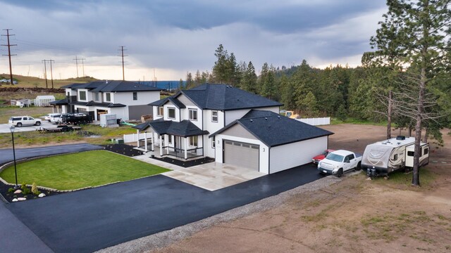 5125 N Ellie Ln, Spokane, WA 99217 - view of front of home featuring roof with shingles, asphalt driveway, a front lawn, a garage, and covered porch