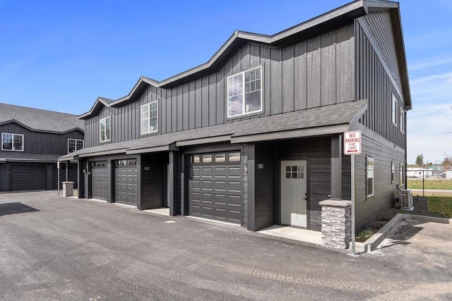 202 S Union Road Building B, Unit 102, Spokane, WA 99206 - view of property with board and batten siding, an attached garage, a shingled roof, and cooling unit