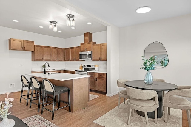 202 S Union Road Building B, Unit 102, Spokane, WA 99206 - kitchen featuring appliances with stainless steel finishes, light wood-style floors, a kitchen island with sink, light countertops, and baseboards