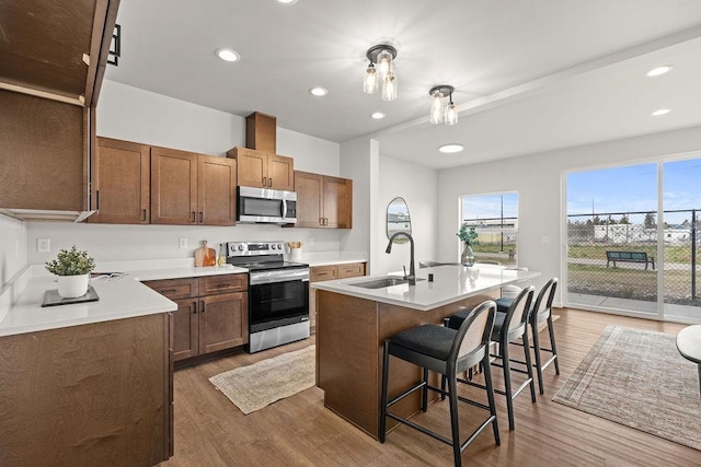 202 S Union Road Building B, Unit 102, Spokane, WA 99206 - kitchen with appliances with stainless steel finishes, a sink, wood finished floors, a breakfast bar area, and light countertops