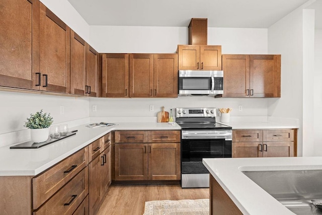 202 S Union Road Building B, Unit 102, Spokane, WA 99206 - kitchen with stainless steel appliances, light wood-style flooring, light countertops, and brown cabinets