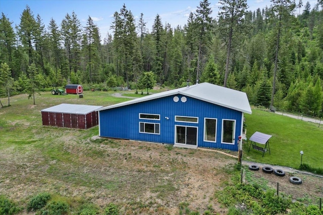 2559F United Copper Mine Rd, Chewelah, WA 99109 - rear view of house featuring a wooded view, a yard, an outbuilding, and a pole building