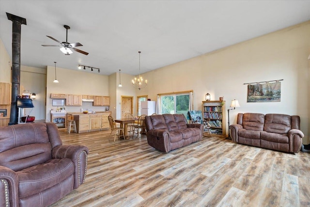 2559F United Copper Mine Rd, Chewelah, WA 99109 - living room featuring a wood stove, light wood-style flooring, track lighting, a chandelier, and a ceiling fan