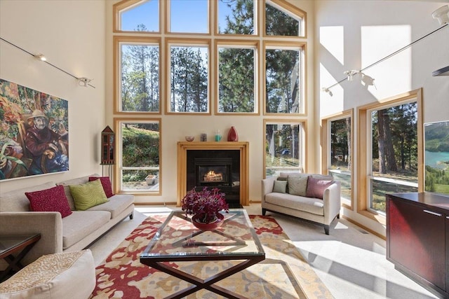 14410 E 45th Ct, Veradale, WA 99037 - living room featuring a high ceiling, healthy amount of natural light, a lit fireplace, and light colored carpet