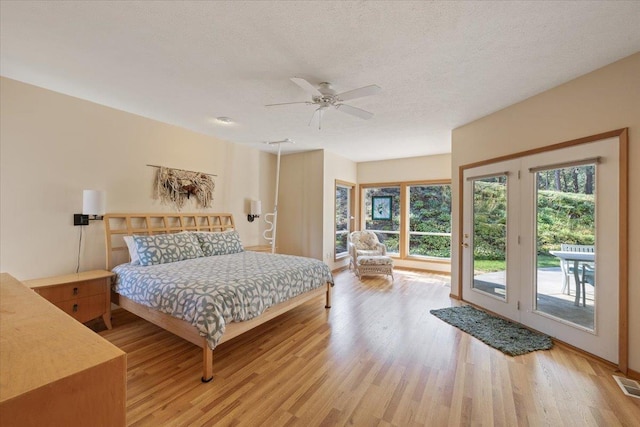 14410 E 45th Ct, Veradale, WA 99037 - bedroom featuring access to exterior, light wood-style floors, a ceiling fan, and a textured ceiling
