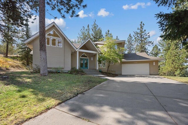 14410 E 45th Ct, Veradale, WA 99037 - view of front facade with concrete driveway, an attached garage, a front lawn, and french doors