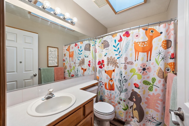 39810 N Hardesty Ln, Elk, WA 99009 - bathroom with a skylight, vanity, toilet, and curtained shower