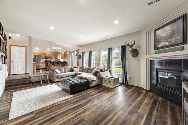 39810 N Hardesty Ln, Elk, WA 99009 - living area with dark wood-type flooring, a chandelier, recessed lighting, and a tiled fireplace