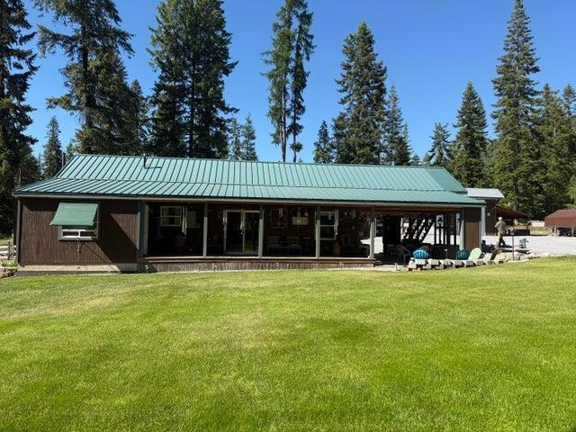3192 Black Canyon Rd, Colville, WA 99114 - rear view of house with a lawn and metal roof