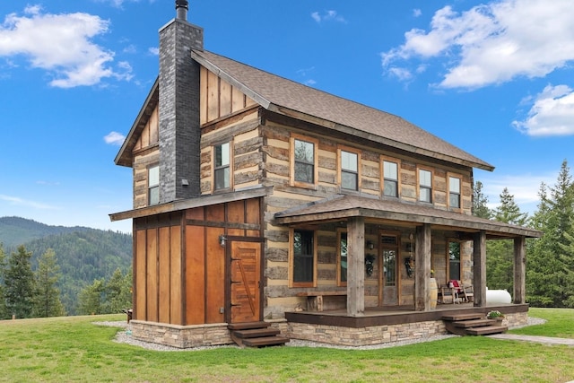 4165 S Varnum Pr, Coeur D Alene, ID 83814 - back of house featuring a lawn, a chimney, a shingled roof, board and batten siding, and a mountain view