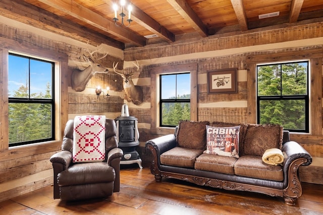 4165 S Varnum Pr, Coeur D Alene, ID 83814 - living room with hardwood / wood-style flooring, healthy amount of natural light, wooden ceiling with exposed beams, a wood stove, and wooden walls