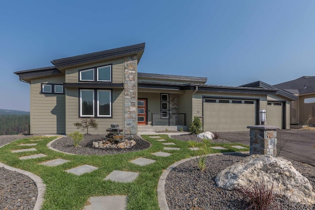207 E Wandermere Heights Ln, Spokane, WA 99208 - prairie-style house featuring a garage, a porch, driveway, and stone siding