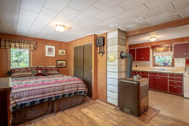 2948 Deep Lake Boundary Rd, Colville, WA 99114 - bedroom with a sink, a wood stove, light wood finished floors, wooden walls, and a closet