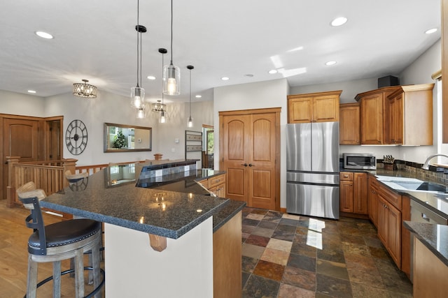 6595D Lois Way, Nine Mile Falls, WA 99026 - kitchen with appliances with stainless steel finishes, recessed lighting, a sink, brown cabinets, and a large island