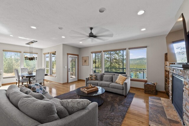 6595D Lois Way, Nine Mile Falls, WA 99026 - living room featuring plenty of natural light, a stone fireplace, baseboards, light wood finished floors, and recessed lighting