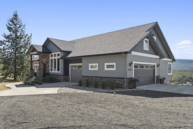 6595D Lois Way, Nine Mile Falls, WA 99026 - view of front of house with concrete driveway, stone siding, roof with shingles, and an attached garage