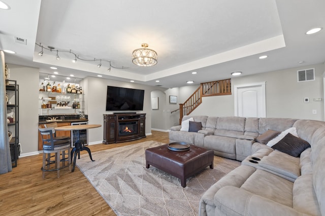 6595D Lois Way, Nine Mile Falls, WA 99026 - living room featuring light wood-type flooring, recessed lighting, a tray ceiling, wine cooler, and stairs