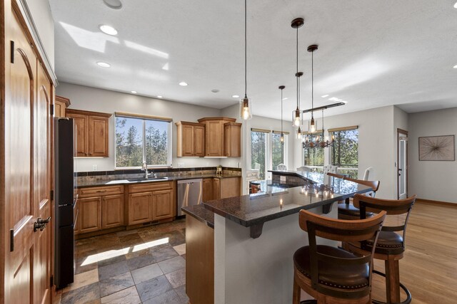 6595D Lois Way, Nine Mile Falls, WA 99026 - kitchen with dishwasher, freestanding refrigerator, a breakfast bar area, a sink, and recessed lighting