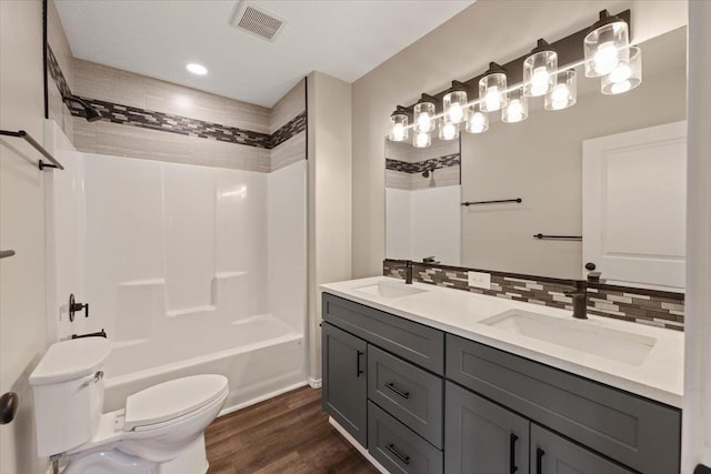 10 S Greenacres Ave, Spokane Valley, WA 99016 - bathroom with toilet, wood finished floors, double vanity, backsplash, and tub / shower combination