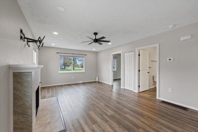 10 S Greenacres Ave, Spokane Valley, WA 99016 - unfurnished living room with a textured ceiling, wood finished floors, ceiling fan, a fireplace, and baseboards