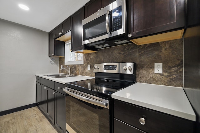 10 S Greenacres Ave, Spokane Valley, WA 99016 - kitchen featuring appliances with stainless steel finishes, a sink, light wood-style flooring, and backsplash