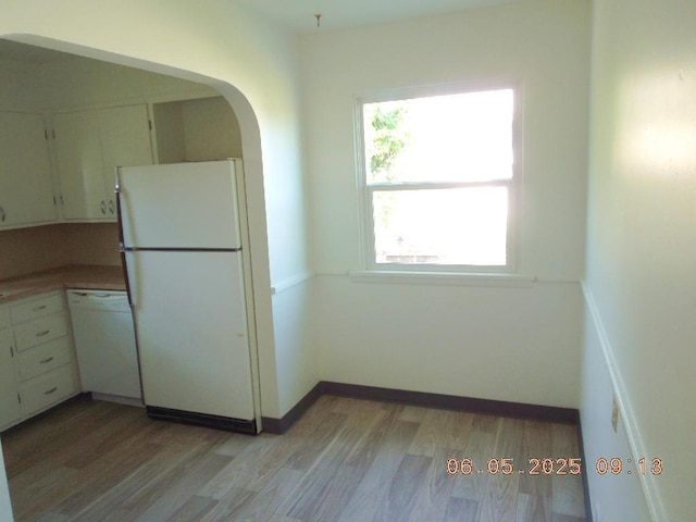 40 E Heroy Ave, Spokane, WA 99207 - kitchen featuring white appliances, light wood-style flooring, arched walkways, and white cabinetry